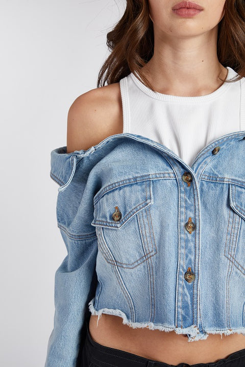Off-shoulder denim jacket with a built-in white ribbed racerback tank top, paired with drapey, baggy black cargo pants for an effortlessly cool look. Crafted from premium Italian denim in a light wash, this slouchy yet elegant 2-in-1 top features a slightly cropped fit, making it the perfect transitional outfit. Designed for versatility, it’s ideal for summer nights or layering through the seasons.