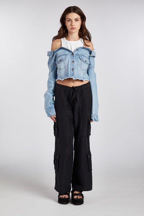 Off-shoulder denim jacket with a built-in white ribbed racerback tank top, paired with drapey, baggy black cargo pants for an effortlessly cool look. Crafted from premium Italian denim in a light wash, this slouchy yet elegant 2-in-1 top is the perfect transitional outfit. It's ideal for summer nights or layering year-round."