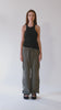 360-degree view of a chic and elegant black racerback tank top with an asymmetric hem, paired with olive green cargo pants. Made from soft, stretchy, and sustainable ribbed knit fabric for a sexy yet versatile fit. The full spin showcases the tank's flattering drape, open-back detail, and styling versatility—from sleek and fitted to relaxed and effortless.